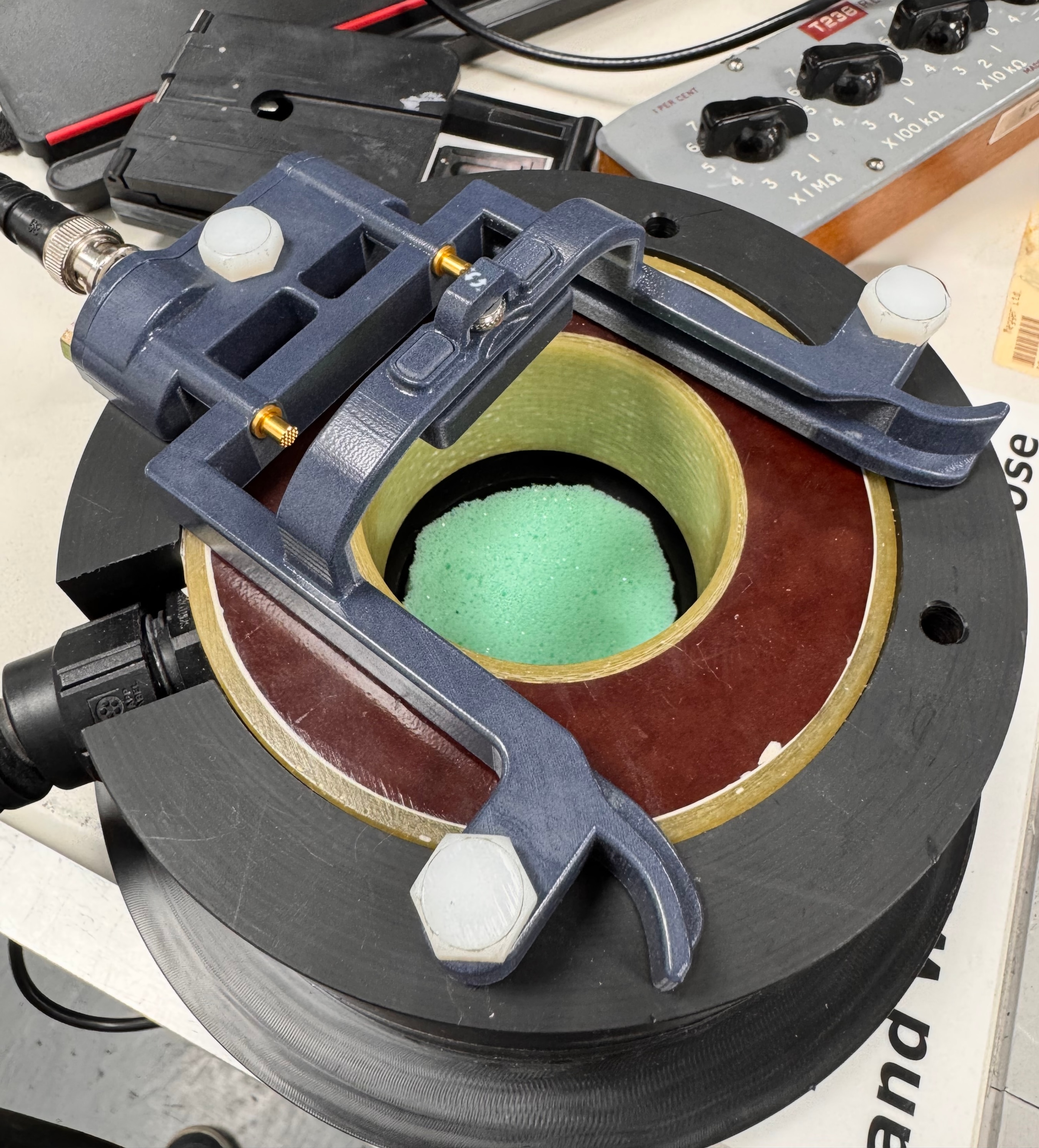 Manufactured demagnetizing fixture with the black spring-contact tray visible above it