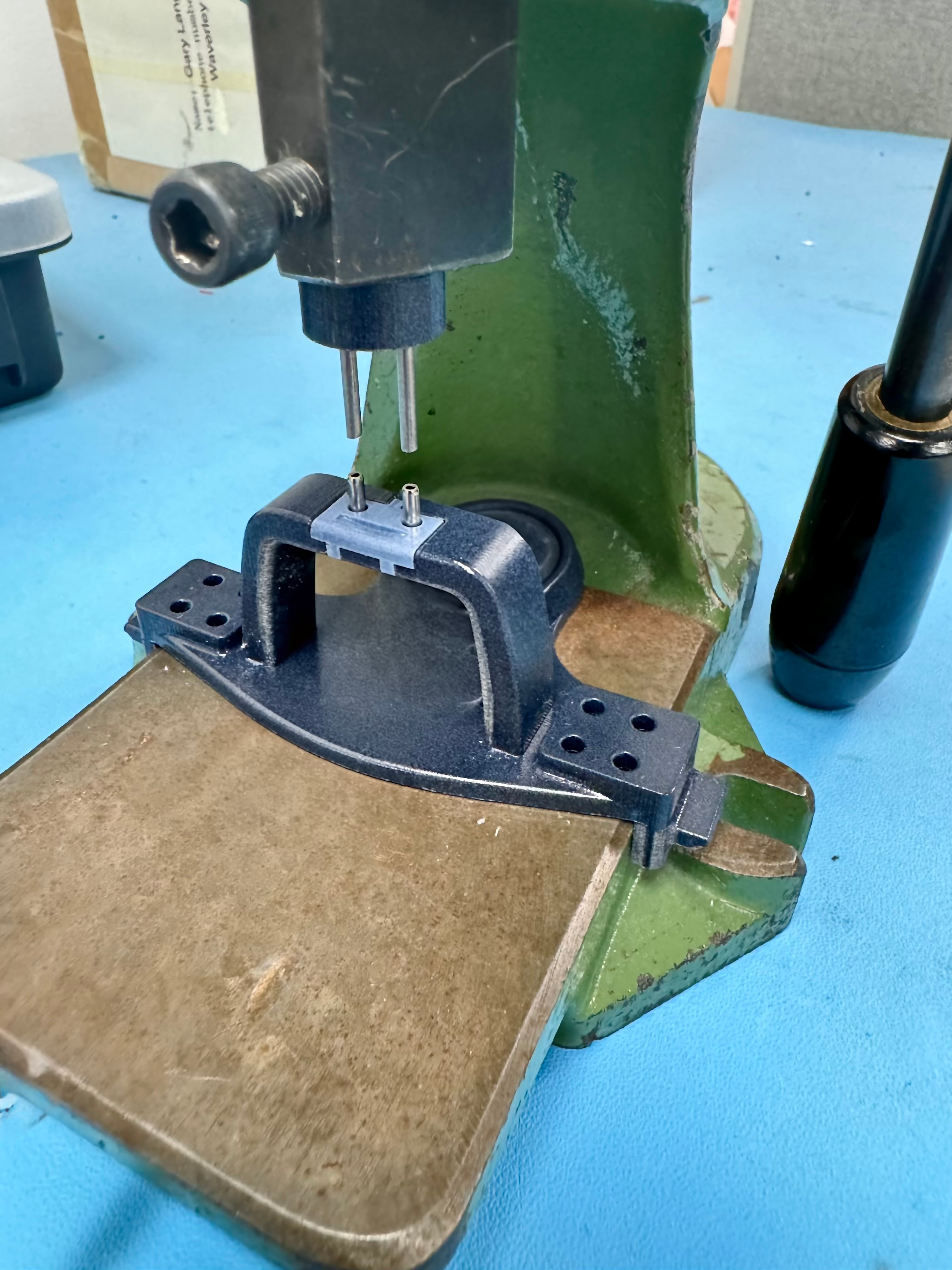 Roll-pin insertion fixture installed on a hand press