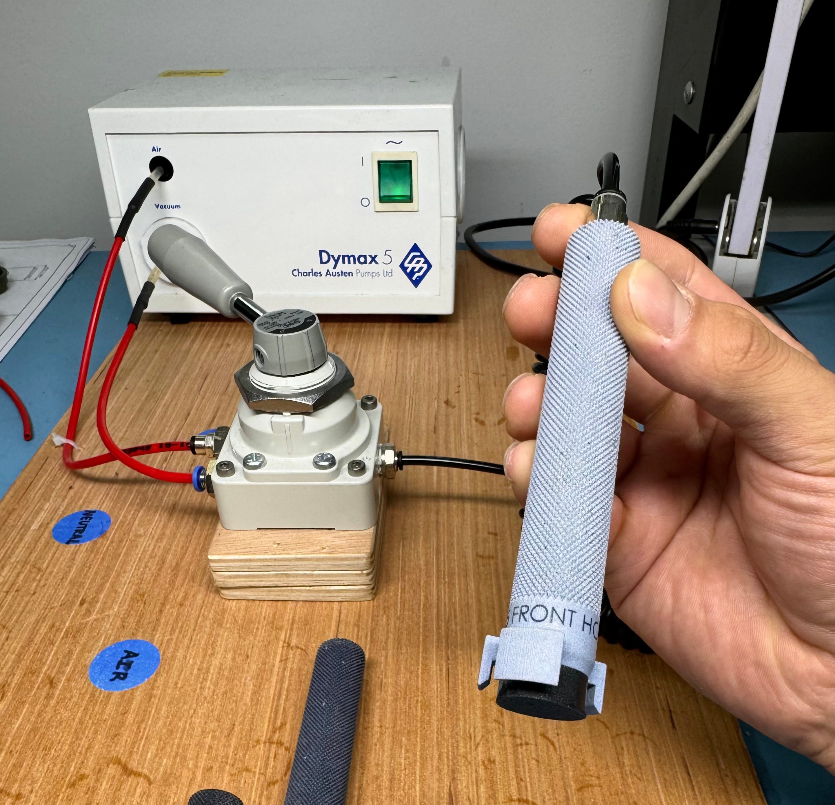 Real membrane-application station showing the four-way valve beneath the Dymax 5 and the manufactured stamp